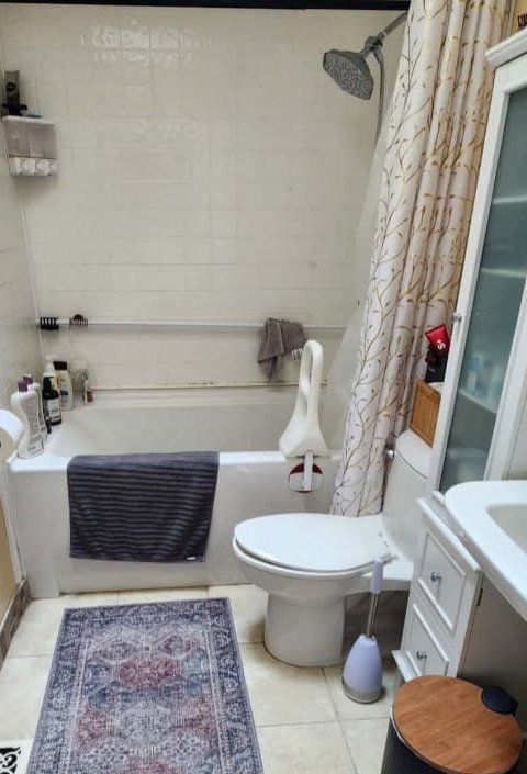 Before: old bathroom with dated tub, tile and shower curtain
