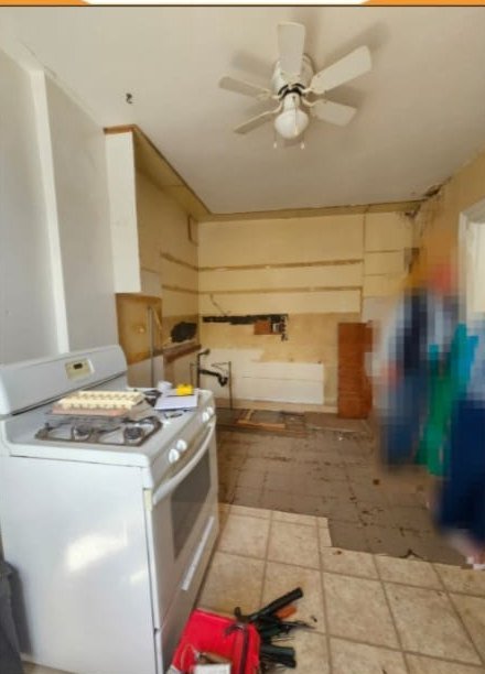 Before: gutted kitchen with bare walls and old appliances